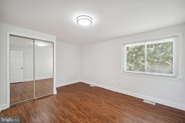 unfurnished bedroom featuring hardwood / wood-style flooring and a closet