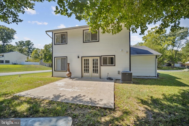 rear view of house featuring a patio, a yard, central AC, and french doors