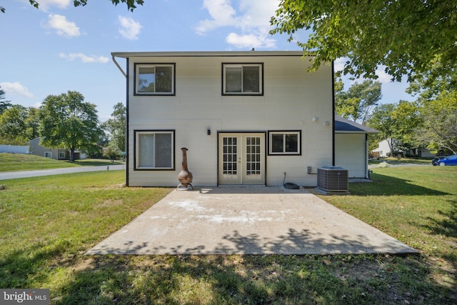 rear view of house featuring cooling unit, a patio area, french doors, and a lawn