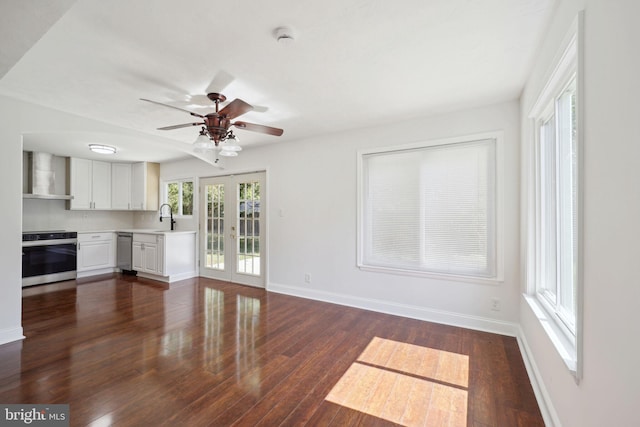 unfurnished living room with french doors, ceiling fan, dark hardwood / wood-style flooring, and sink