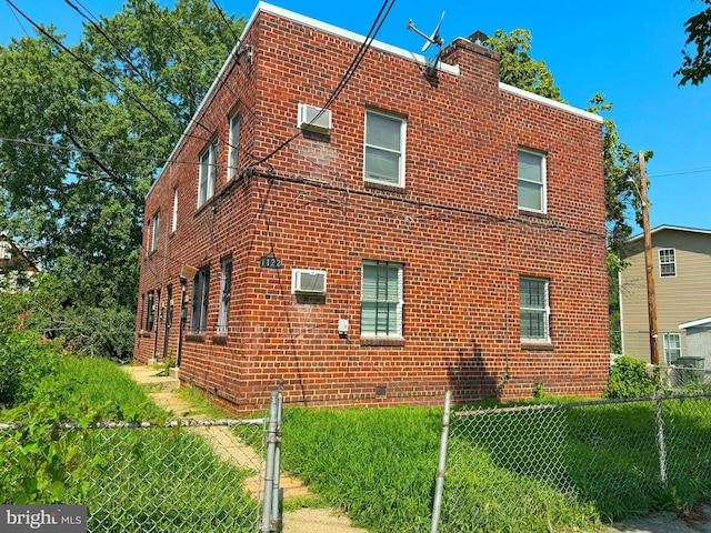 view of property exterior featuring a yard and a wall mounted AC