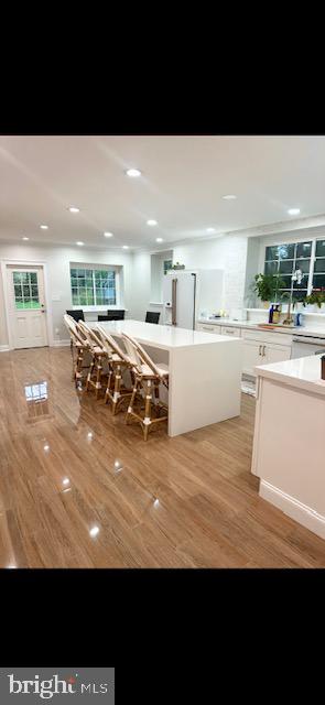 kitchen featuring light hardwood / wood-style flooring, white cabinets, and white refrigerator with ice dispenser