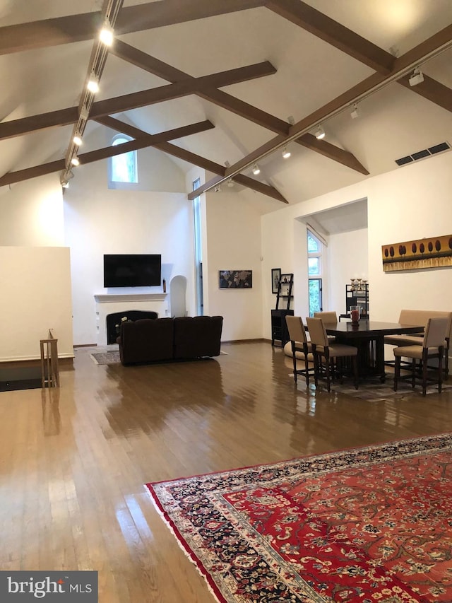 living room with plenty of natural light, high vaulted ceiling, and wood-type flooring