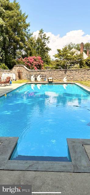 view of swimming pool with a diving board