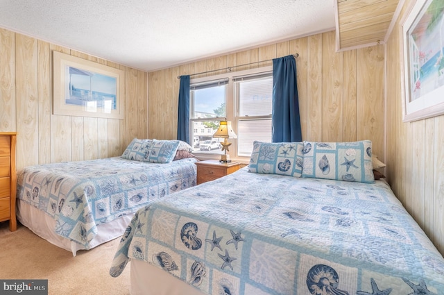 carpeted bedroom with wooden walls and a textured ceiling