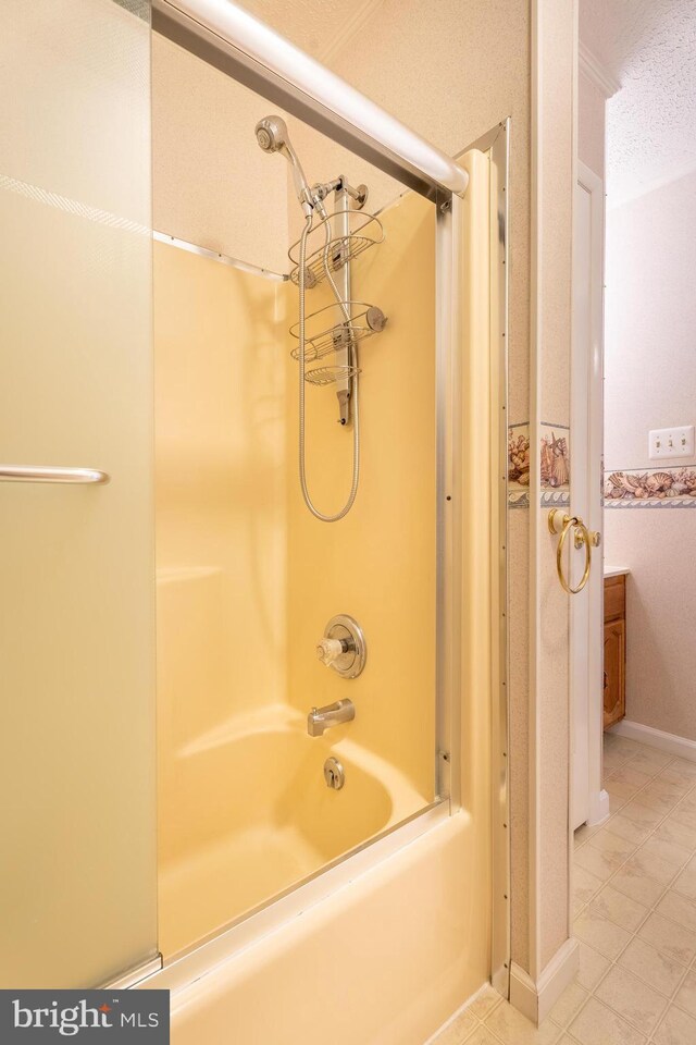 bathroom with a textured ceiling, tile patterned flooring, and tub / shower combination