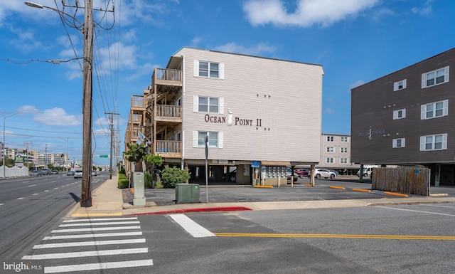 view of building exterior featuring central AC unit and uncovered parking