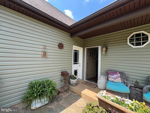 doorway to property featuring roof with shingles