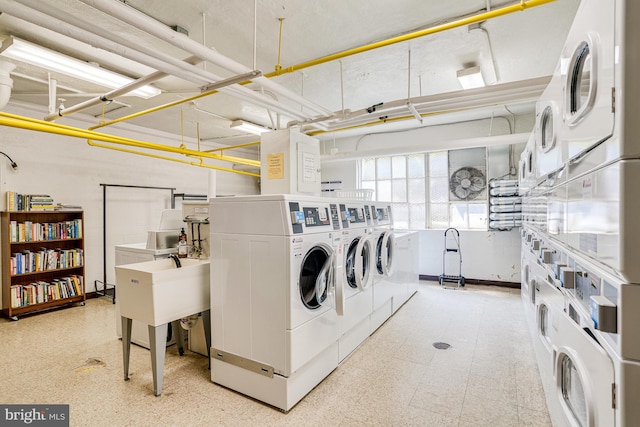 laundry room with sink, stacked washer / drying machine, and washer and clothes dryer