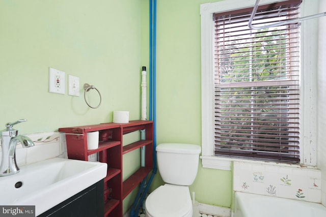 bathroom featuring a bath, vanity, and toilet