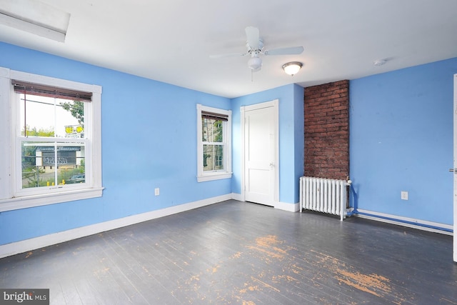 interior space with dark wood-type flooring, radiator heating unit, and ceiling fan