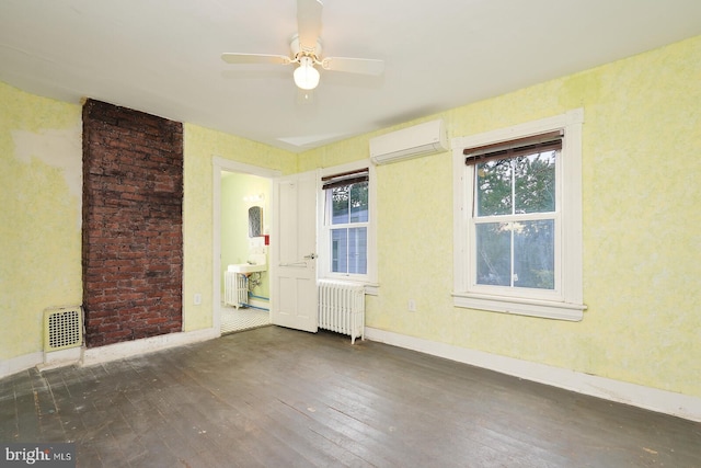 unfurnished room featuring dark hardwood / wood-style floors, radiator heating unit, a wall unit AC, and ceiling fan