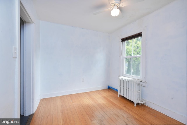 empty room with radiator, ceiling fan, and light wood-type flooring