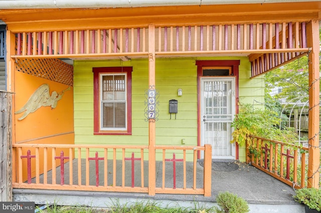 view of exterior entry featuring covered porch