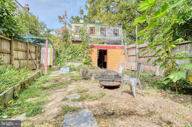 view of yard with a shed and an outdoor fire pit