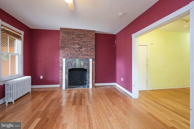 unfurnished living room featuring radiator, ceiling fan, and hardwood / wood-style floors