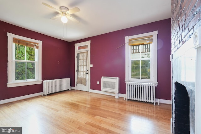 spare room with radiator heating unit, ceiling fan, and hardwood / wood-style floors