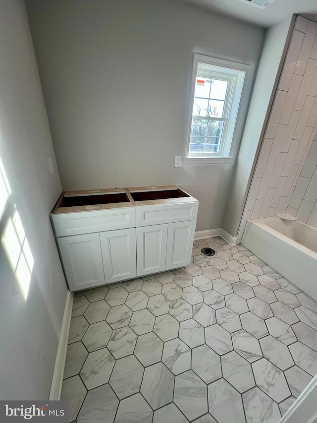 full bathroom with a washtub and baseboards