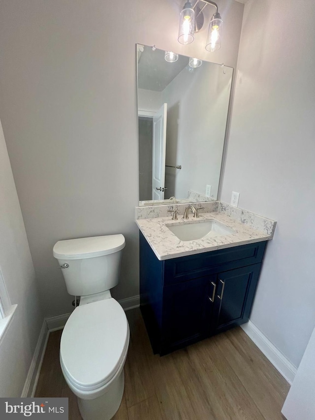 bathroom featuring toilet, baseboards, and wood finished floors