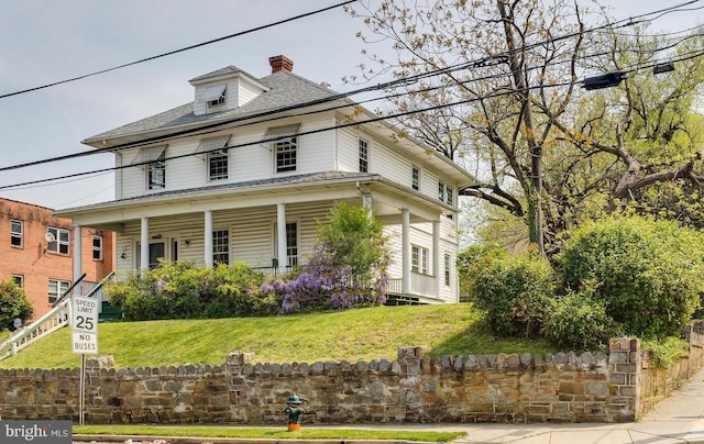 view of front of house featuring a front lawn and covered porch