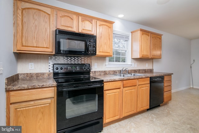 kitchen with baseboards, light brown cabinetry, a sink, black appliances, and backsplash