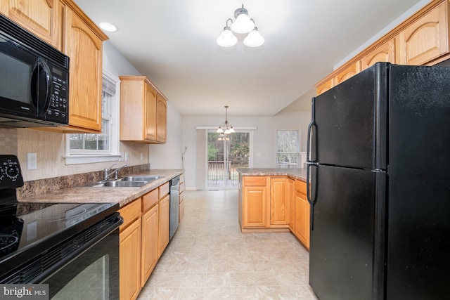 kitchen featuring light brown cabinets, a chandelier, decorative light fixtures, black appliances, and a sink