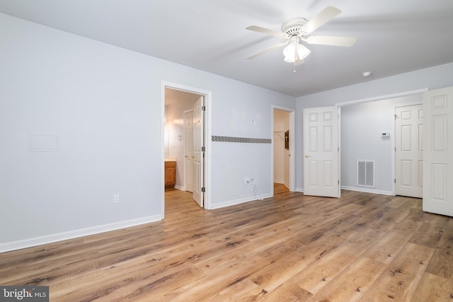 unfurnished bedroom with visible vents, connected bathroom, baseboards, ceiling fan, and light wood-style floors