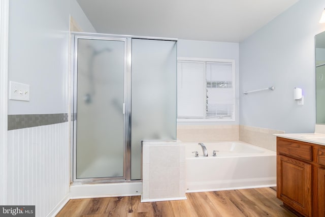 full bathroom featuring vanity, a garden tub, wood finished floors, and a stall shower