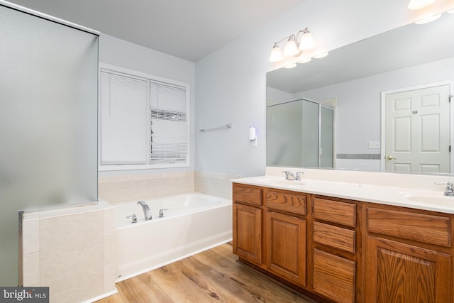 full bath with a sink, a garden tub, a stall shower, and double vanity