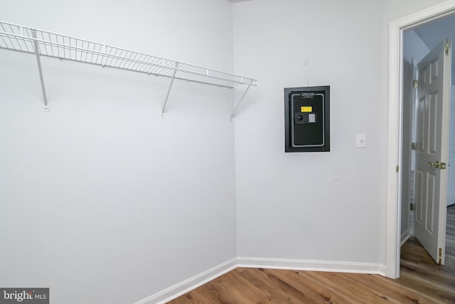 walk in closet with wood finished floors