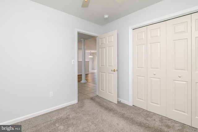 unfurnished bedroom with light carpet, ornate columns, a closet, and ceiling fan