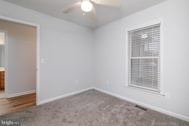 spare room featuring baseboards, visible vents, carpet floors, and ceiling fan