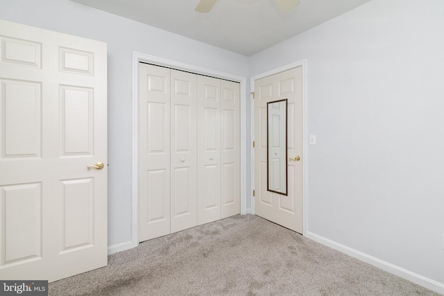 unfurnished bedroom featuring a closet, carpet flooring, a ceiling fan, and baseboards