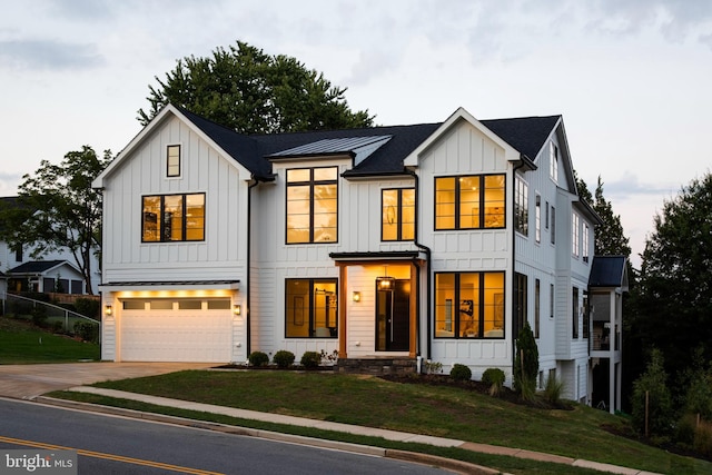 modern farmhouse style home featuring a front yard and a garage