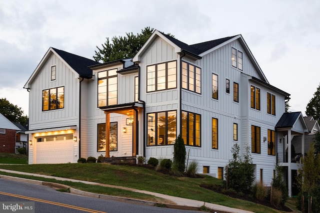 modern farmhouse style home with a front lawn and a garage