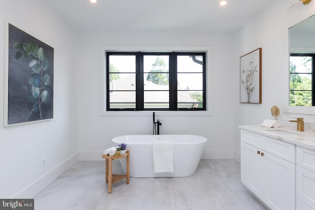 bathroom featuring vanity, a healthy amount of sunlight, and a bathing tub