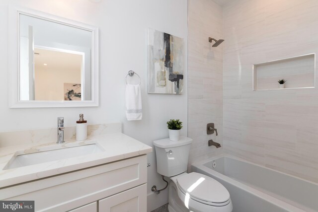 full bathroom featuring toilet, tiled shower / bath combo, and vanity