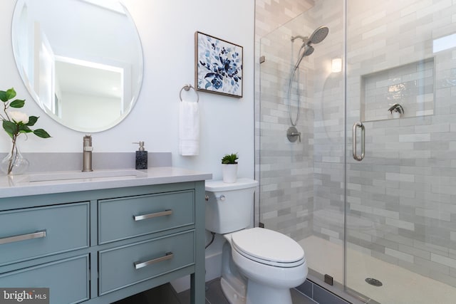 bathroom featuring walk in shower, toilet, and vanity