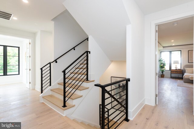 stairs featuring a wealth of natural light and hardwood / wood-style floors