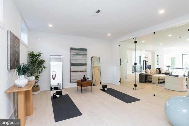 exercise room with light hardwood / wood-style floors