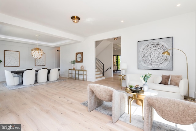 living room with an inviting chandelier and light hardwood / wood-style flooring