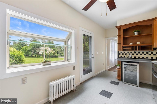 kitchen featuring radiator, a wealth of natural light, ceiling fan, and beverage cooler