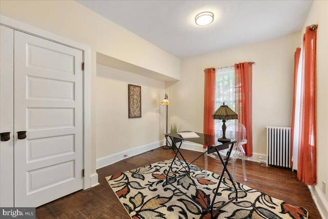 sitting room with radiator heating unit and dark wood-type flooring