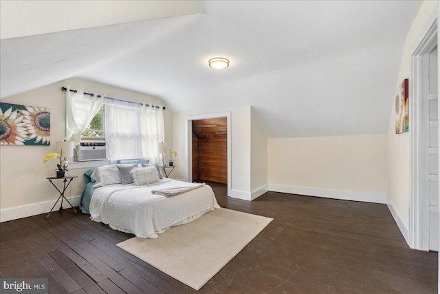 bedroom with dark hardwood / wood-style floors, vaulted ceiling, and cooling unit