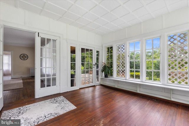 unfurnished sunroom featuring radiator and plenty of natural light