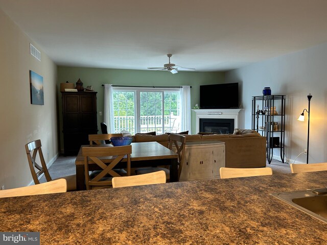 living area with carpet floors, a fireplace with flush hearth, and baseboards