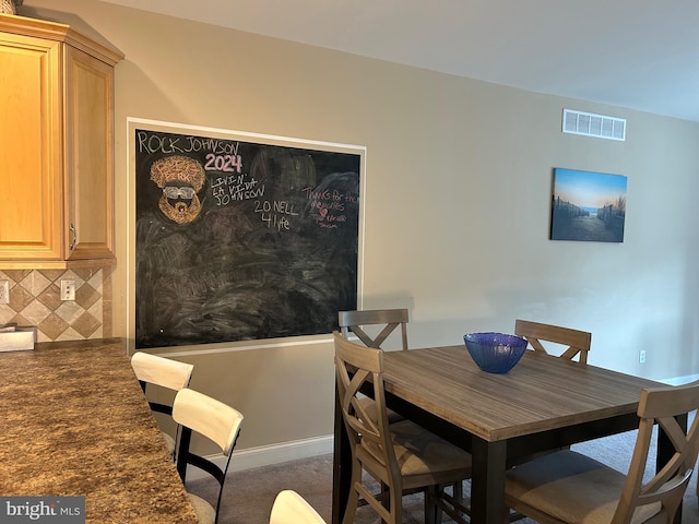 dining space with carpet, baseboards, and visible vents