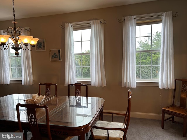 dining room featuring carpet, a notable chandelier, and a wealth of natural light