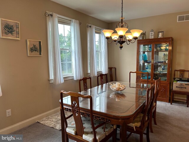 dining space with carpet, a notable chandelier, and baseboards