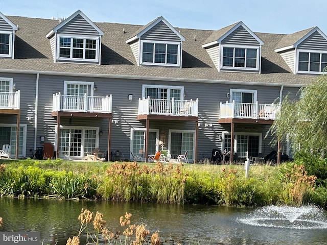 back of house featuring a water view and a balcony